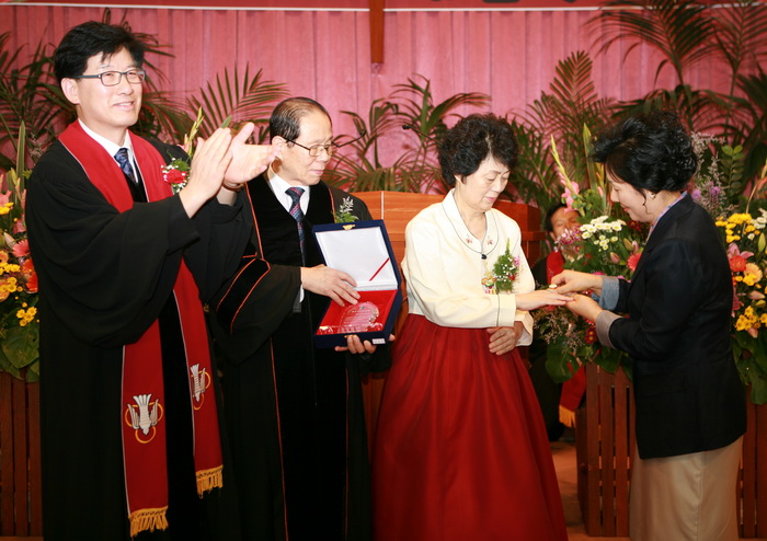 원로목사 김용진 목사 사모에게 반지를 증정하고 있는 유성은 목사.jpg